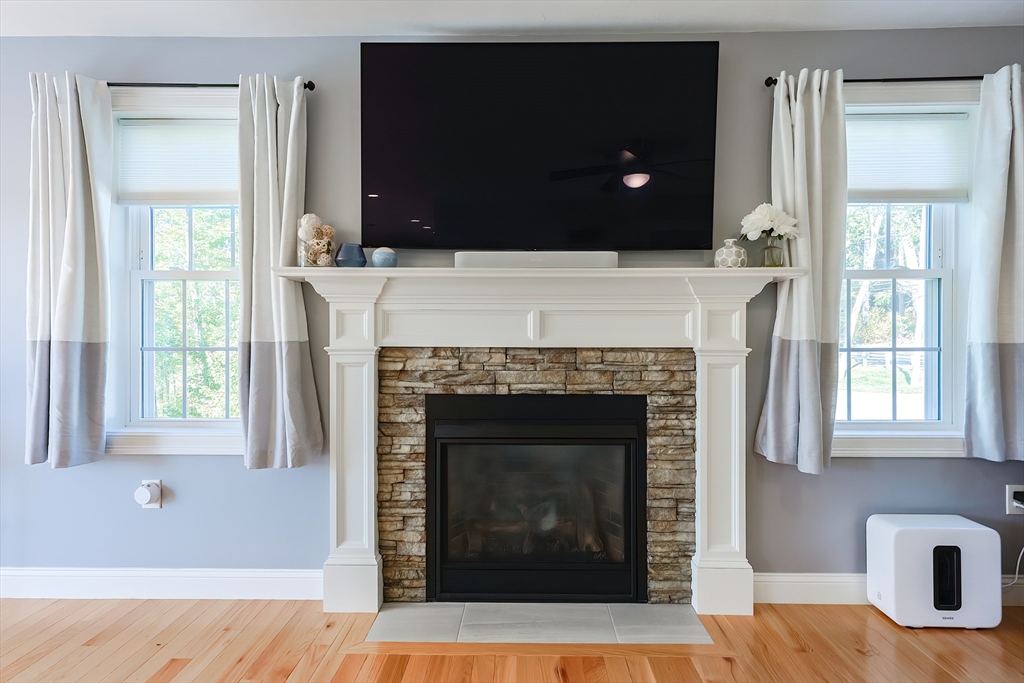 131 Pommogussett Road Rutland, MA 01543 - Photo 6 of 38 a living room with a fireplace a flat screen tv and a window