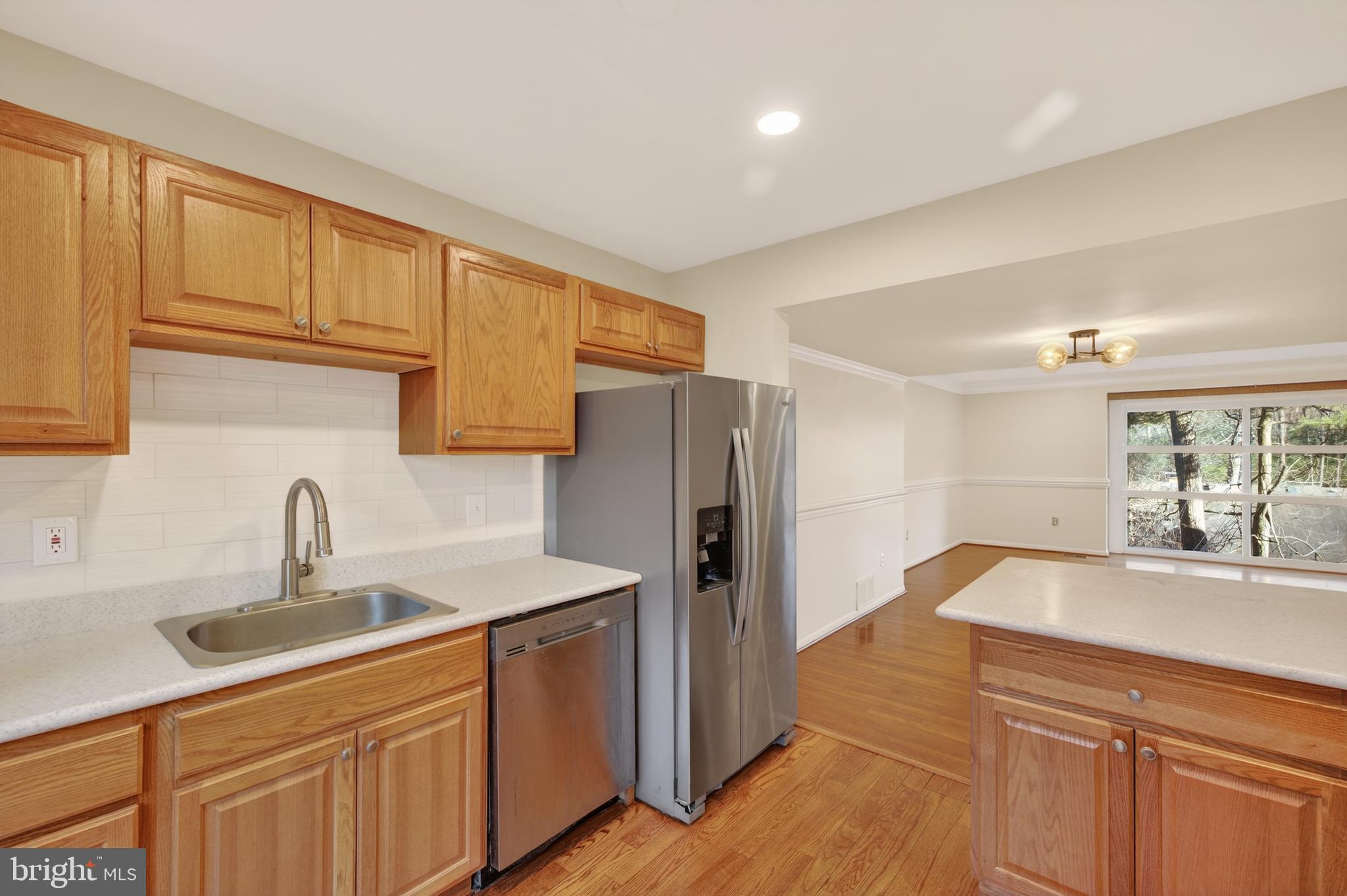 9250 Three Oaks Drive Silver Spring, MD 20901 - Photo 14 of 45 a kitchen with stainless steel appliances granite countertop a sink and a refrigerator