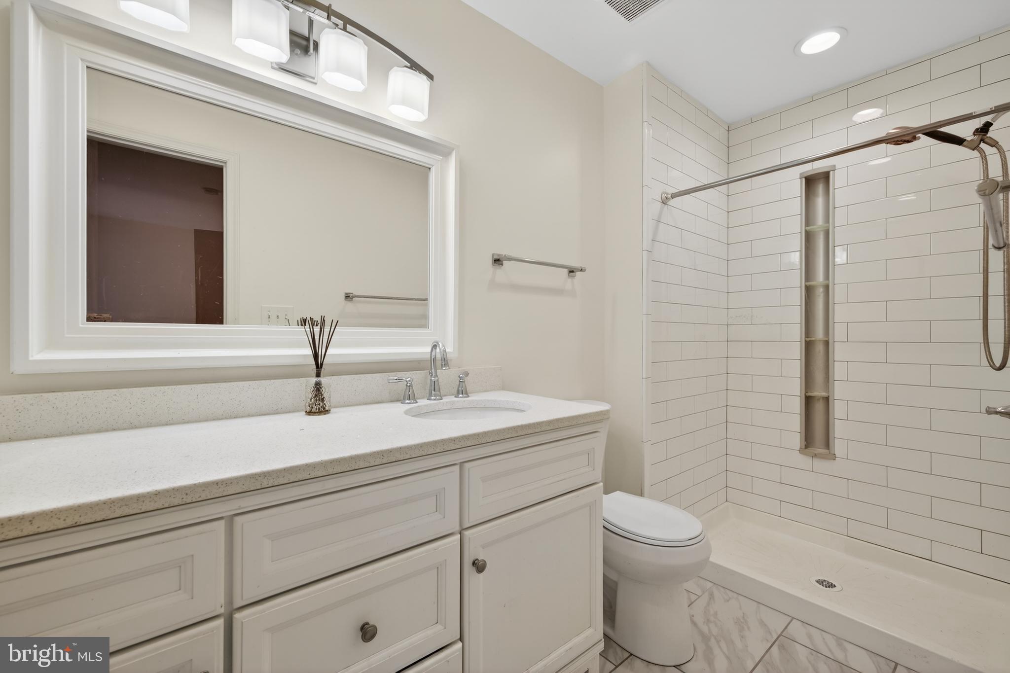 9250 Three Oaks Drive Silver Spring, MD 20901 - Photo 22 of 45 a bathroom with a granite countertop sink a toilet and shower