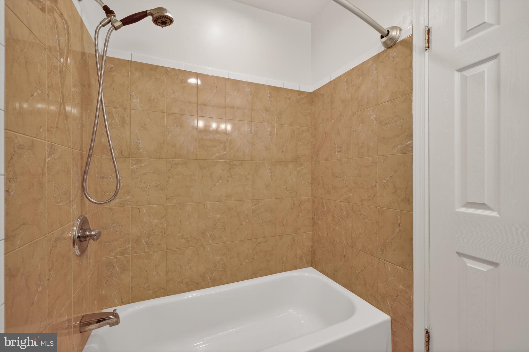 9250 Three Oaks Drive Silver Spring, MD 20901 - Photo 31 of 45 a bathroom with a white bath tub and a shower