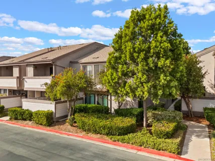 a front view of a house with plants and garden