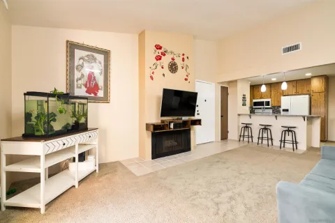 a living room with stainless steel appliances furniture and a flat screen tv
