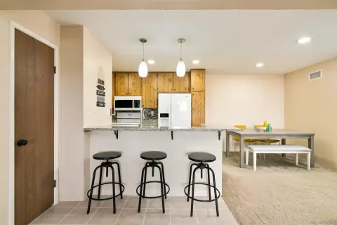 a kitchen with stainless steel appliances kitchen island granite countertop a table and chairs in it