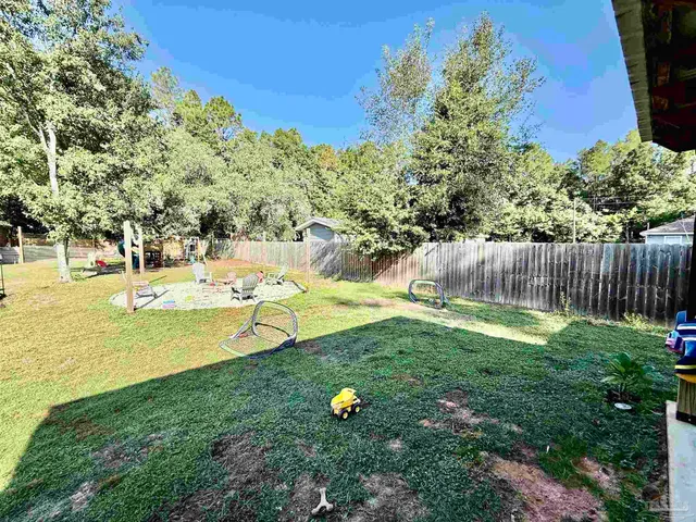a view of a backyard with furniture and a fire pit