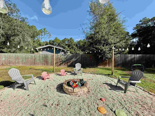 a backyard of a house with table and chairs