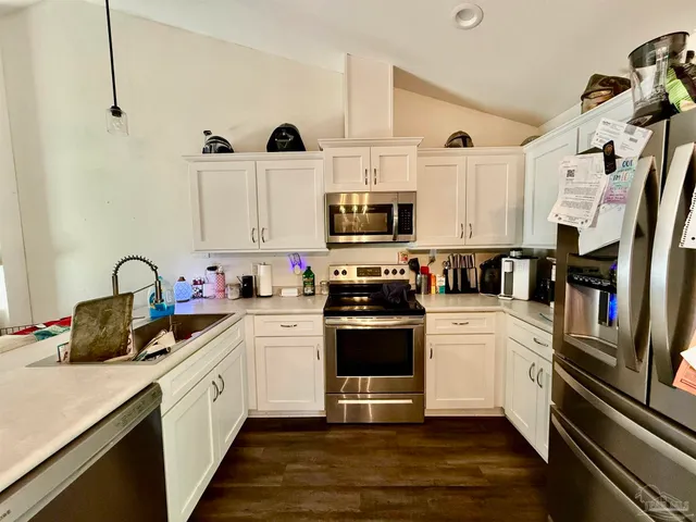 a kitchen with stainless steel appliances and white cabinets