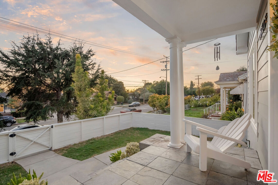 a view of backyard with large trees and plants