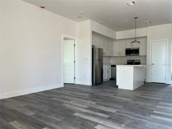 a view of kitchen with stainless steel appliances a refrigerator and a stove top oven