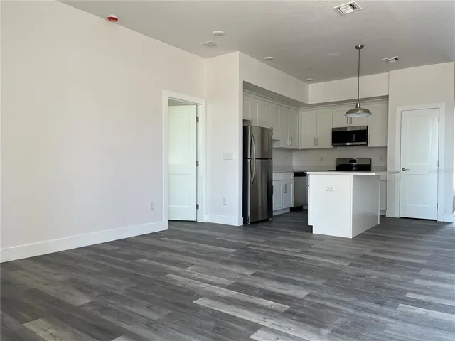 a view of kitchen with stainless steel appliances a refrigerator and a stove top oven