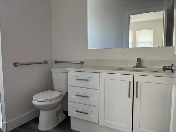 a bathroom with a sink a toilet and a mirror