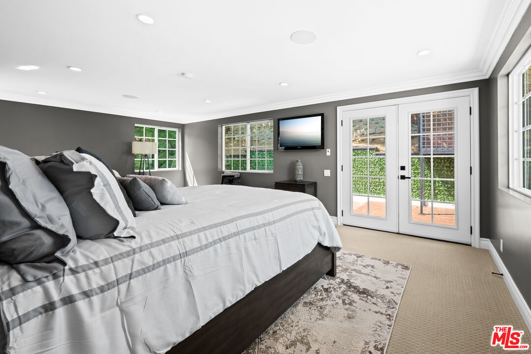 2563 Hutton Drive Beverly Hills, CA 90210 - Photo 44 of 69 a bedroom with a large bed and a flat tv screen on dresser