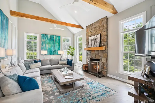 a living room with fireplace furniture and a large window