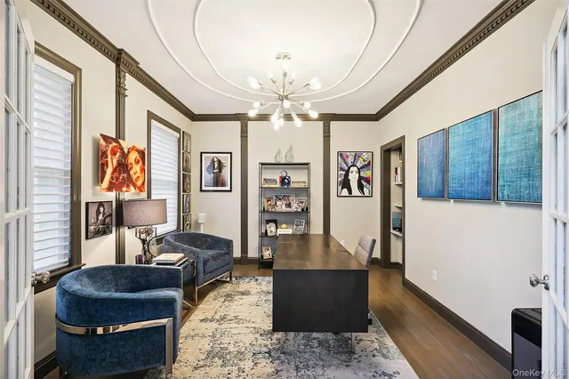a living room with furniture a chandelier and a flat screen tv