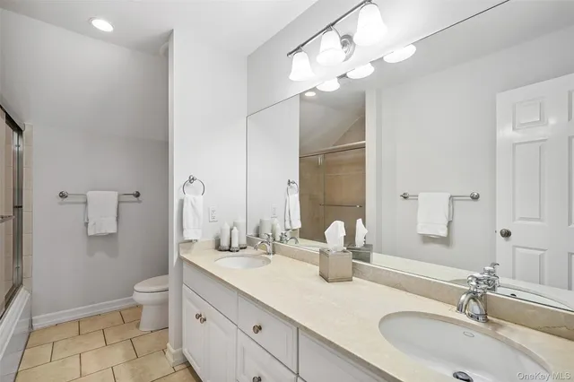 a bathroom with a double vanity sink mirror and toilet
