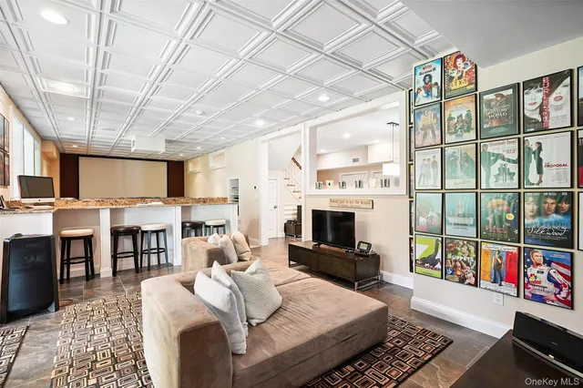 a living room with furniture a flat screen tv and a floor to ceiling window