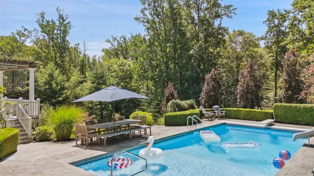 a view of patio with couches and table under an umbrella