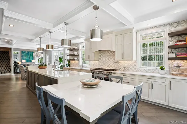 a kitchen with stainless steel appliances granite countertop a stove a sink dishwasher a dining table and chairs with wooden floor