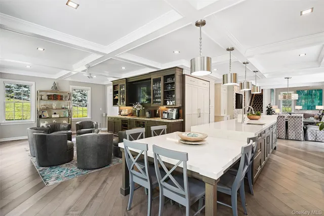a dining room with stainless steel appliances kitchen island granite countertop a table chairs and a kitchen view