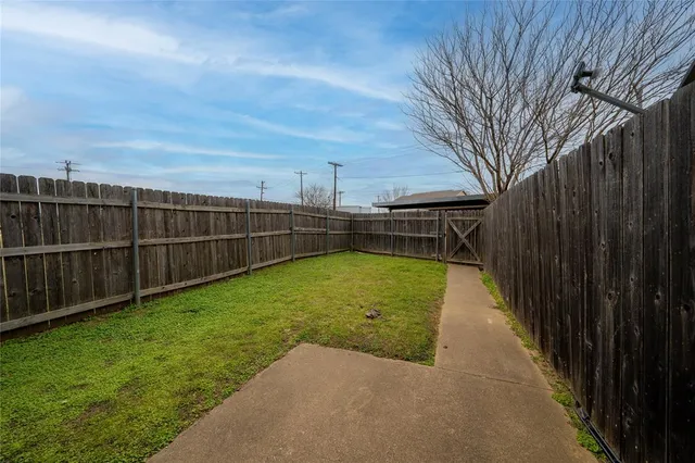 a view of a backyard with wooden fence