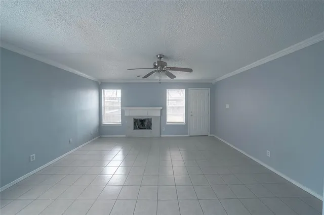 an empty room with windows and fireplace