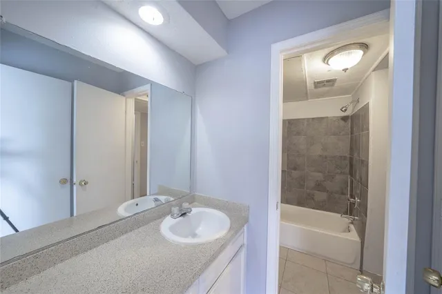 a bathroom with a tub sink and mirror