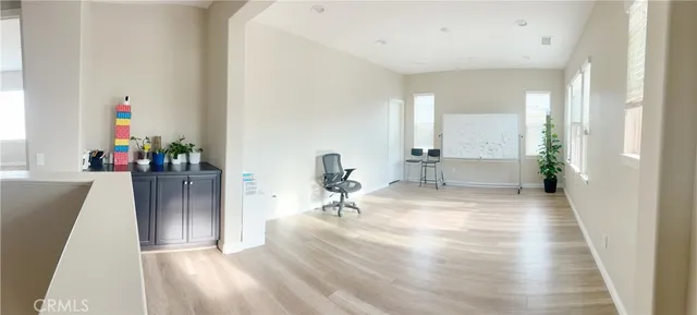 a view of a hallway with a dining table and chairs