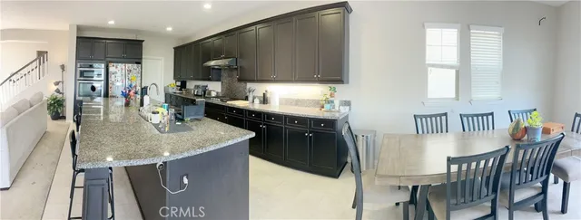 a kitchen with a stove a sink a dining table and chairs