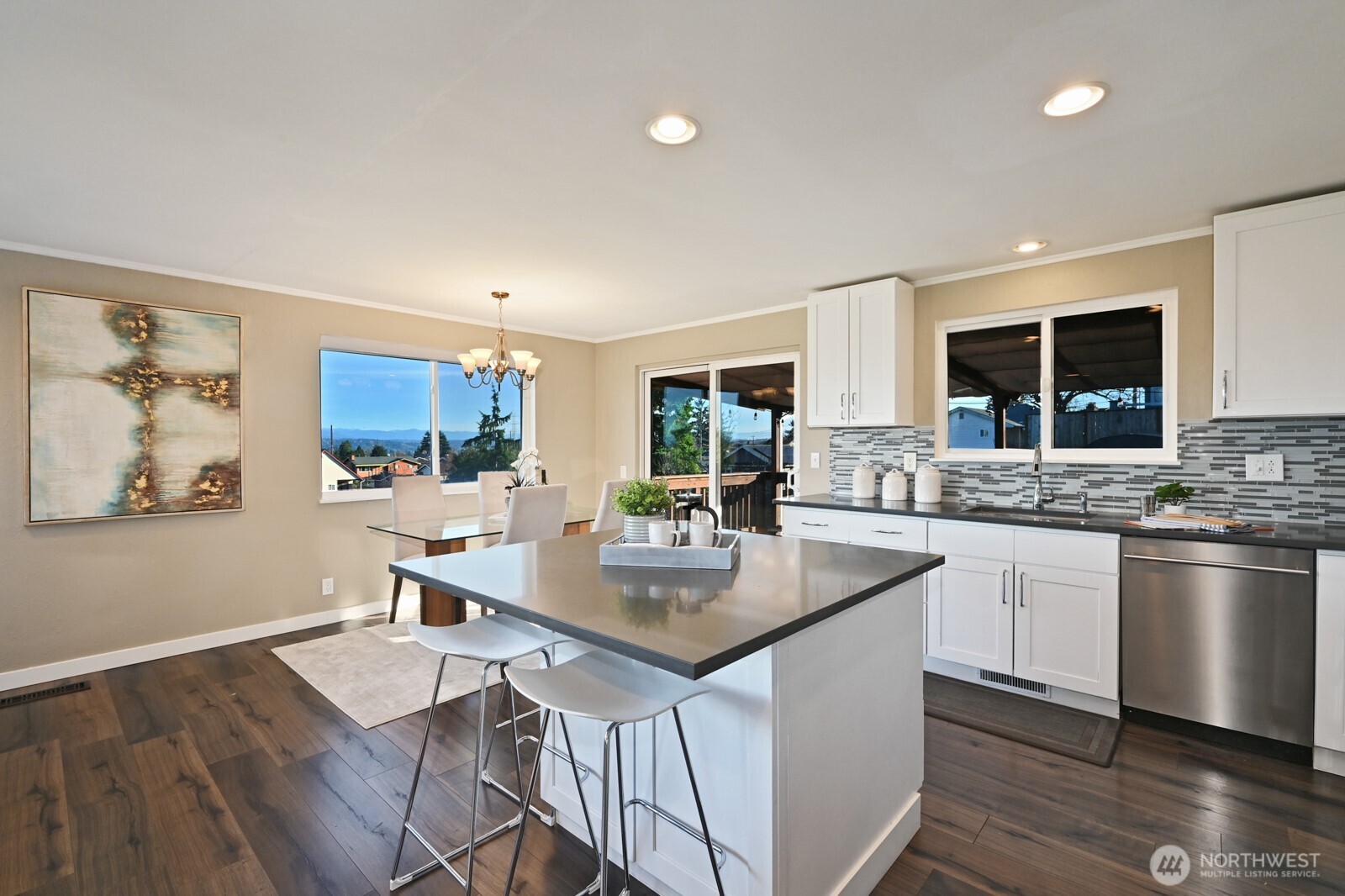 2525 South Raymond Street Seattle, WA 98108 - Photo 10 of 38 a kitchen with stainless steel appliances granite countertop a stove top oven a sink dishwasher a dining table and chairs with wooden floor