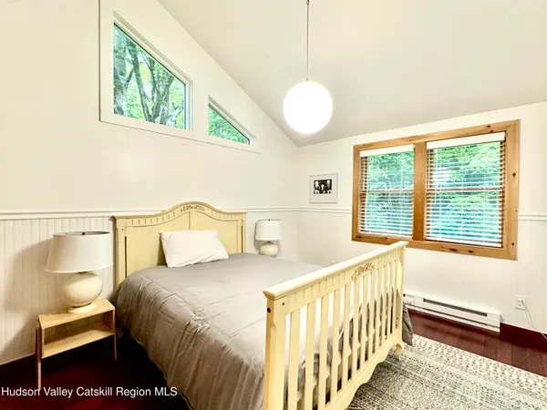 a bedroom with a bed and a painting on the wall