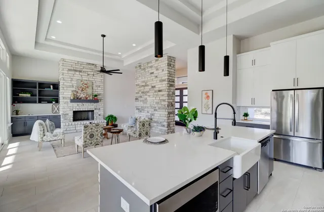 a large kitchen with kitchen island a large counter top space a sink a stove and a chandelier