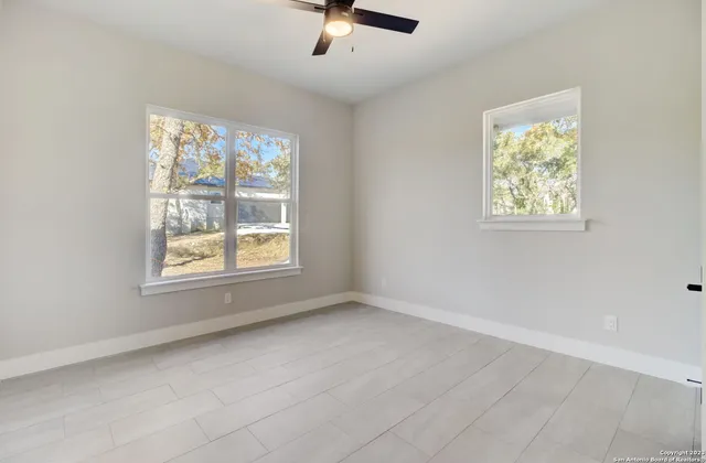 an empty room with windows and bathroom view