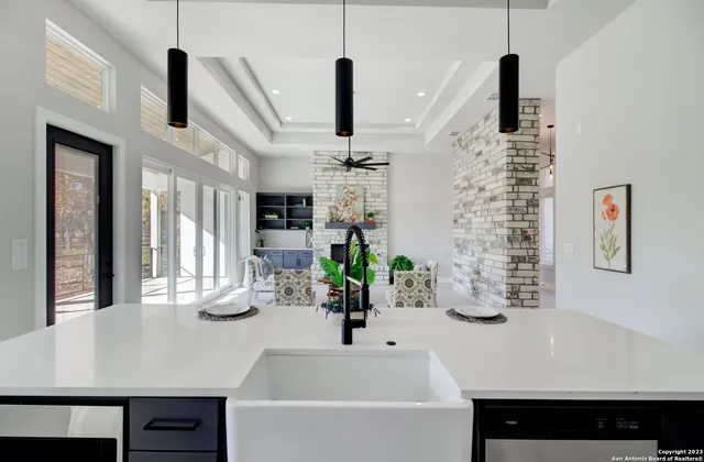 a kitchen with stainless steel appliances sink refrigerator and fireplace