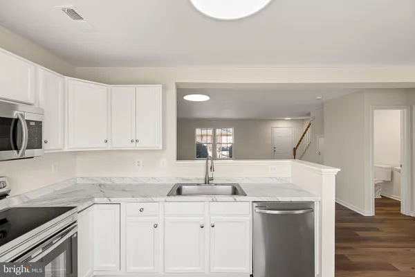 a kitchen with granite countertop a sink and a stove top oven