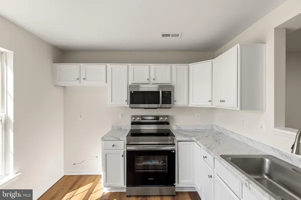 a kitchen with granite countertop a stove and a sink