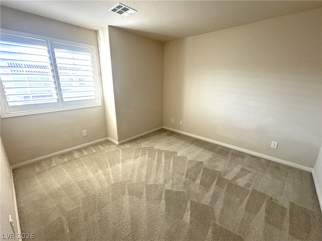 121 Elm Reed Avenue Las Vegas, NV 89113 - Photo 24 of 30 Sun-filled room featuring plush carpeting and pristine white window blinds, ready for personalization.