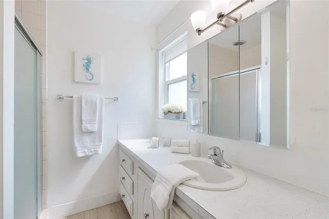 a bathroom with a sink vanity tub and shower