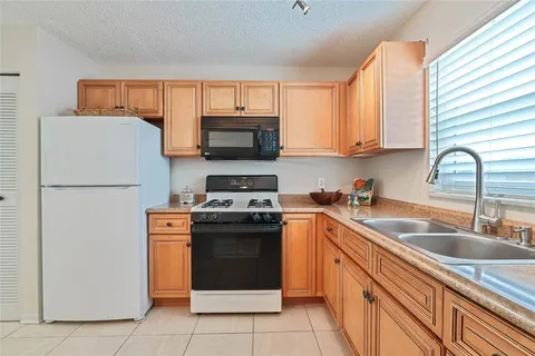 a kitchen with stainless steel appliances granite countertop a refrigerator stove a sink dishwasher and microwave