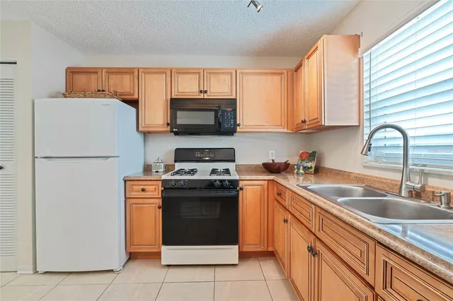 a kitchen with stainless steel appliances granite countertop a refrigerator stove a sink dishwasher and microwave