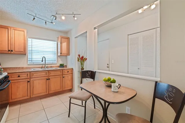 a kitchen with stainless steel appliances granite countertop a sink a table and chairs