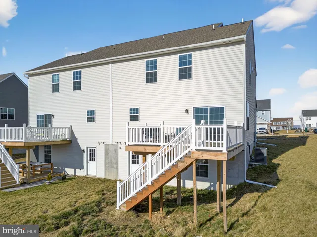 a view of a house with wooden deck and furniture