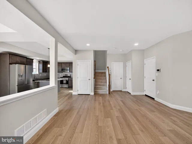 a view of a big room with wooden floor and windows