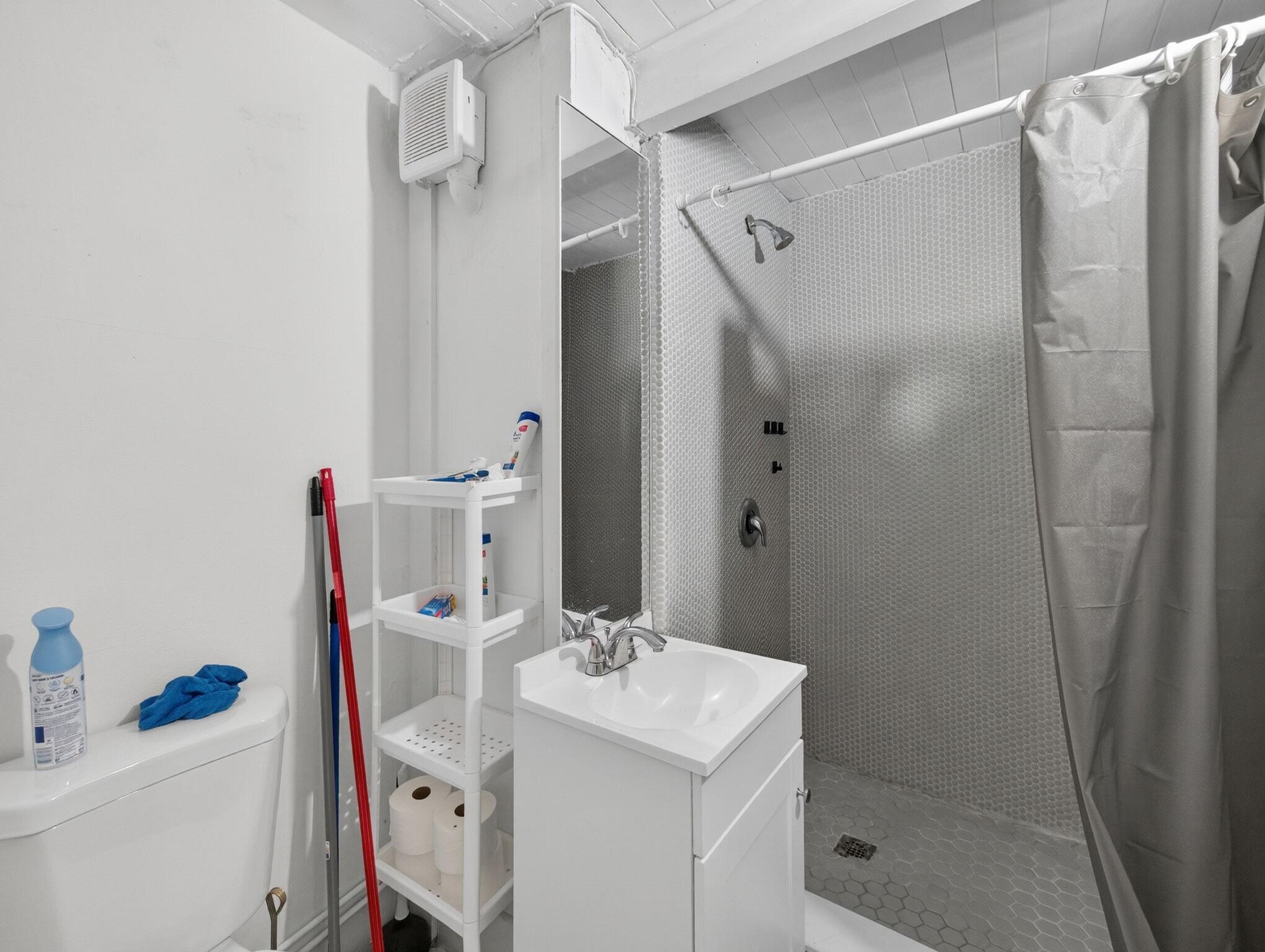7026 Pine Tree Lane Lake Clarke Shores, FL 33406 - Photo 17 of 22 a bathroom with a sink mirror and shower