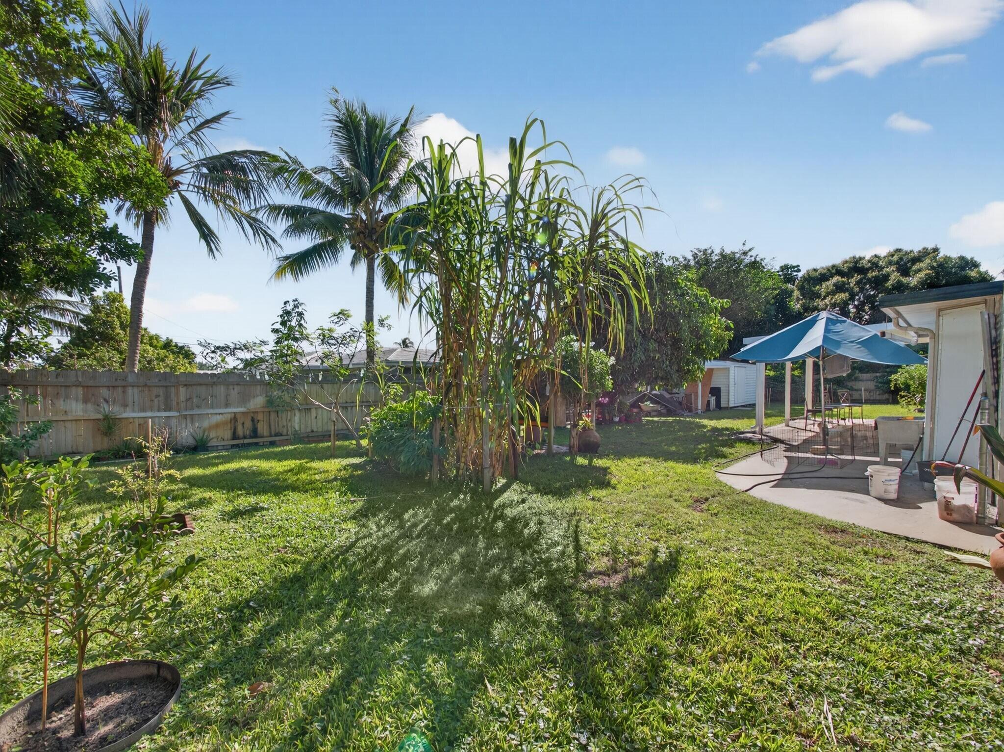 7026 Pine Tree Lane Lake Clarke Shores, FL 33406 - Photo 20 of 22 a view of a house with a yard and sitting area