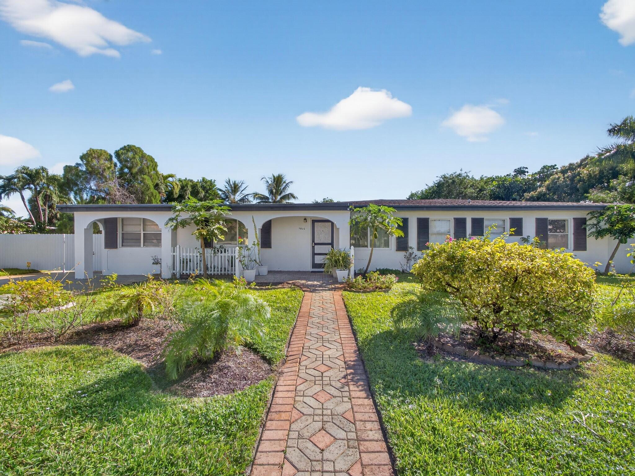 7026 Pine Tree Lane Lake Clarke Shores, FL 33406 - Photo 2 of 22 a front view of house with yard and green space