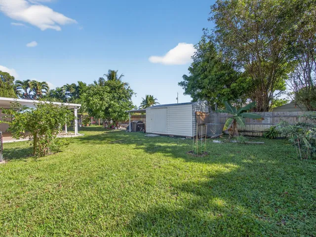 a view of a house with a big yard and a large tree center