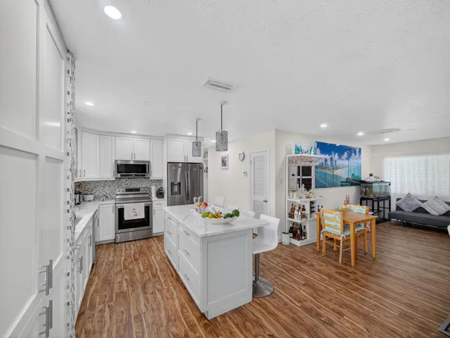 a kitchen with a refrigerator and a stove top oven