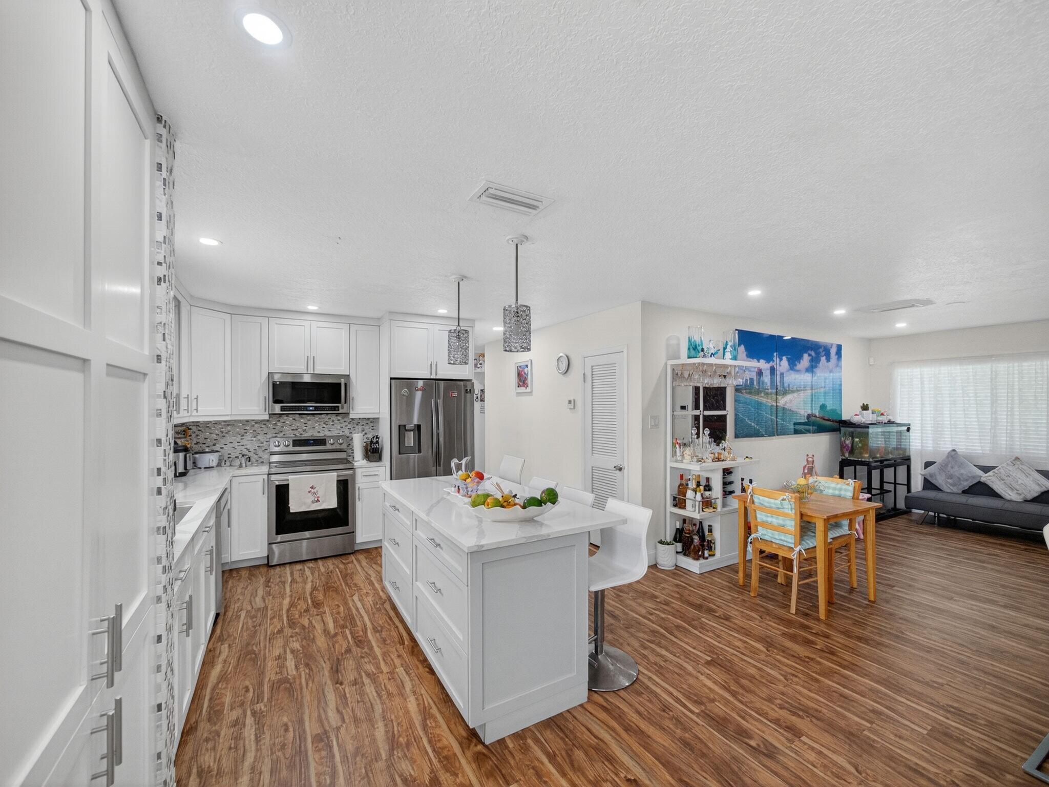 7026 Pine Tree Lane Lake Clarke Shores, FL 33406 - Photo 6 of 22 a kitchen with a refrigerator and a stove top oven
