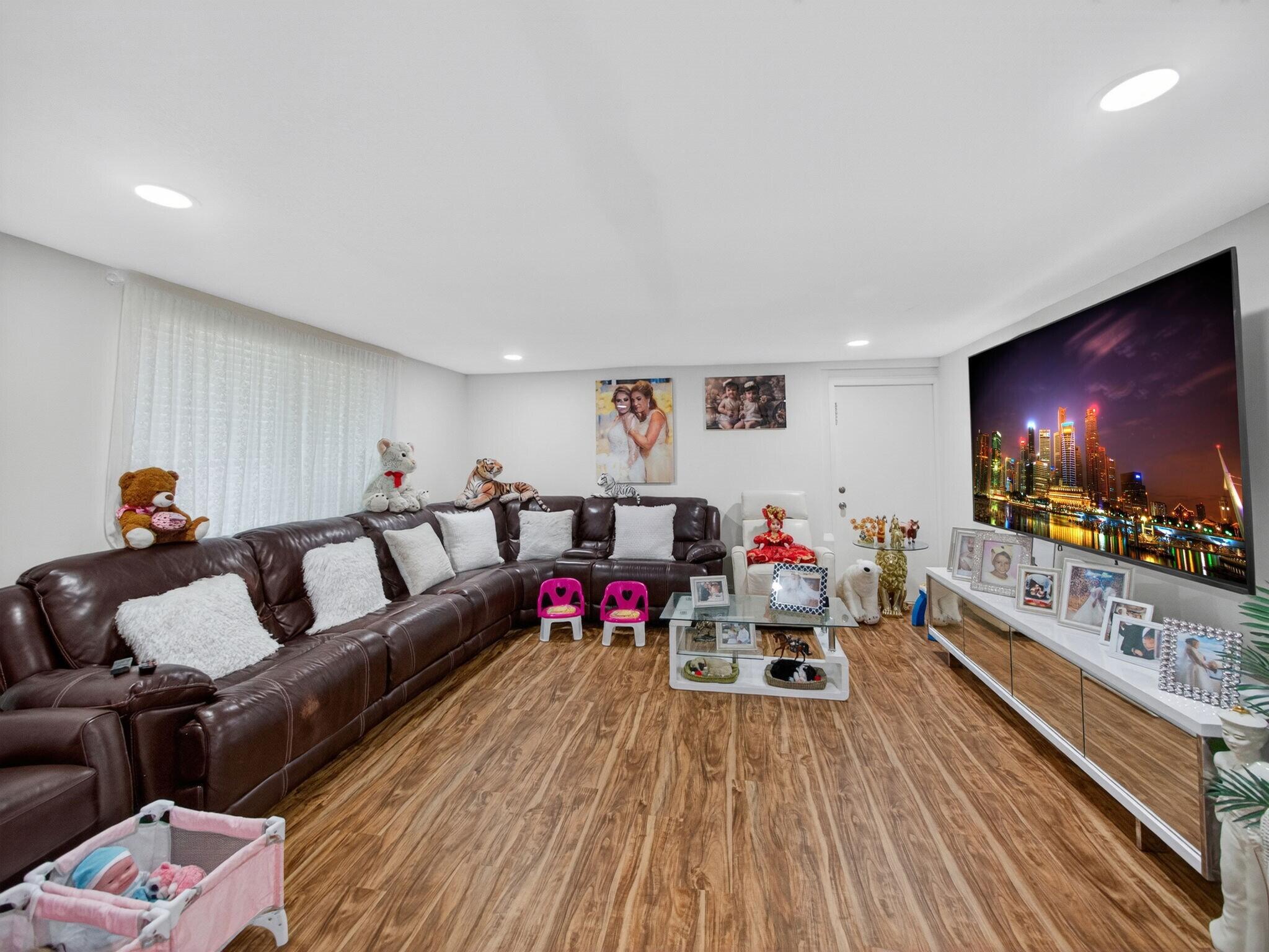 7026 Pine Tree Lane Lake Clarke Shores, FL 33406 - Photo 7 of 22 a living room with furniture and a flat screen tv
