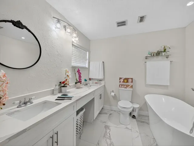 a bathroom with a sink mirror and toilet