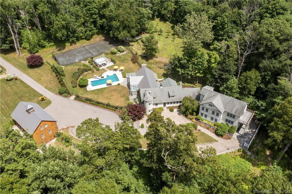 an aerial view of a house with a yard and trees